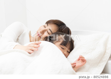 子供を寝かせる母親の写真素材