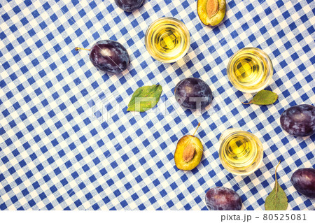 Plums and shot glasses with rakia on the table Plums and shot glasses with rakia on the table 80525081