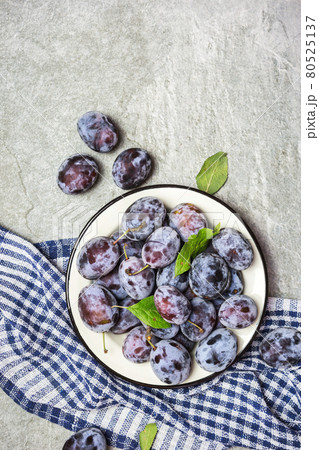 Ripe blue plums on a plate Ripe blue plums on a plate 80525137