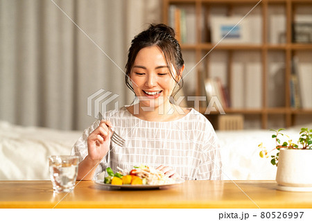夕食を食べる若い女性 80526997