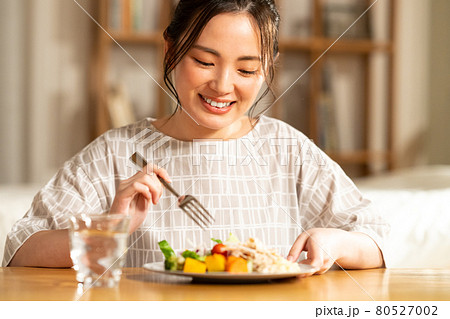 夕食を食べる若い女性 80527002