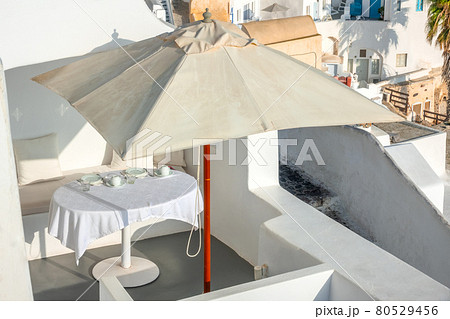 Served Table Under an Umbrella on the Terrace of Santorini 80529456