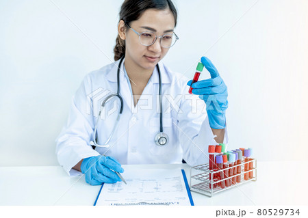 The doctor hand holding the blood tube and records examination results and medication usage of the patient on the chart, medical check-up concept 80529734