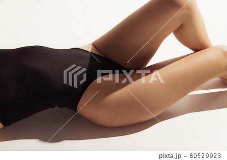 Close up female body in black underwear over white background. 80529923