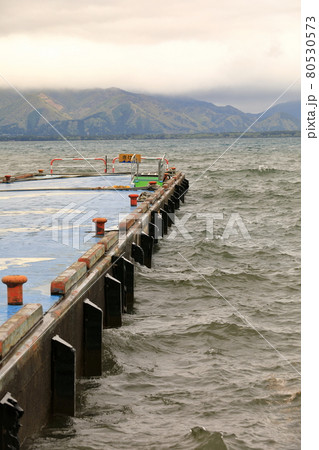 orange Rusty bollard on blue pier at inawashiro lake, Japan. 80530573