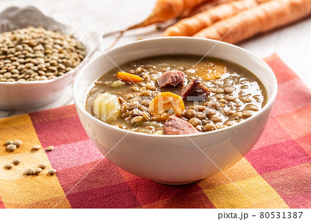 Lentil soup with pieces of smoked pork neck, carrots and potatoes 80531387