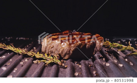 Delicious juicy meat steak cooking on grill. Prime beef fry on electric roaster, rosemary, black pepper, salt. Slow motion. Delicious juicy meat steak cooking on grill. Prime beef fry on electric roaster, rosemary, black pepper, salt. Slow motion. 80531998