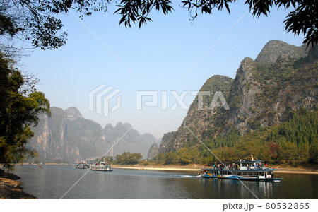 Boats on the Li River between Guilin and Yangshuo in Guangxi Province, China. The karst hills and river scenery have provided inspiration for artists and poets. Li River scenery, Guilin. 80532865