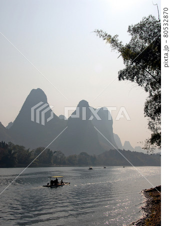 Boats on the Li River between Guilin and Yangshuo in Guangxi Province, China. The karst hills and river scenery have provided inspiration for artists and poets. Sunlight on the Li River, Guilin. 80532870
