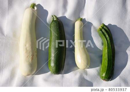 Raw zucchini on a white tablecloth on the grass. Raw zucchini on a white tablecloth on the grass. 80533937