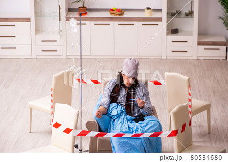 Young sick man suffering at home in pandemic concept Young sick man suffering at home in pandemic concept 80534680