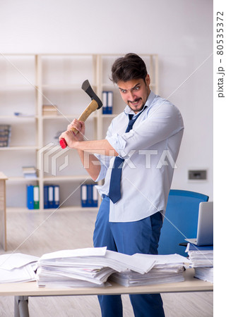 Young male employee unhappy with excessive work in the office 80535372