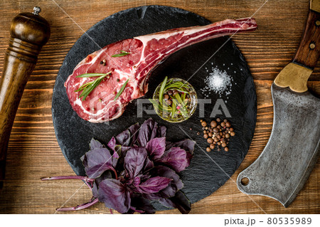 Dry aged raw tomahawk beef steak with ingredients for grilling Dry aged raw tomahawk beef steak with ingredients for grilling 80535989