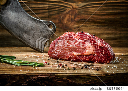 Dry aged Ribeye Steak with seasoning on wooden background. Dry aged Ribeye Steak with seasoning on wooden background. 80536044