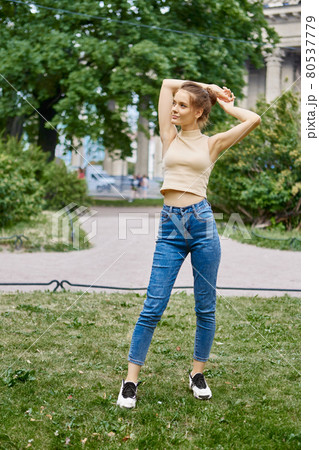 Sexy young woman is walking in city garden at daytime. Sexy young woman is walking in city garden at daytime. 80537779