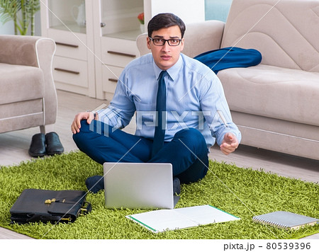 Businessman taking work home and working overtime Businessman taking work home and working overtime 80539396
