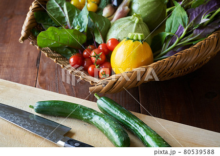 かごに盛られた夏野菜と、まな板と包丁 かごに盛られた夏野菜と、まな板と包丁 80539588