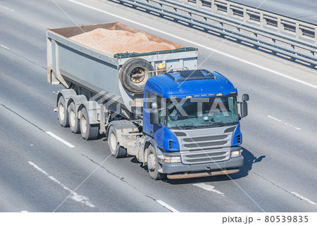 Freight truck with bulk cargo moves on the highway. Freight truck with bulk cargo moves on the highway. 80539835