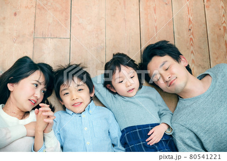 リビングで並んで寝転ぶ団欒する家族のライフスタイルイメージ 80541221