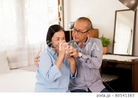 Asian elderly couple drinking milk for breakfast in bedroom together,Retirement senior lifestyle living concept 80541365