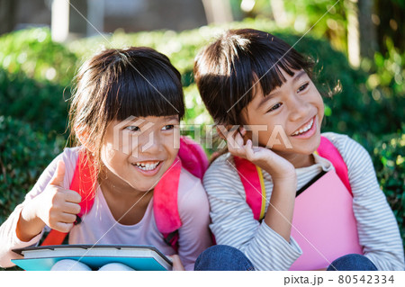 kid student laughing while sitting in the park 80542334