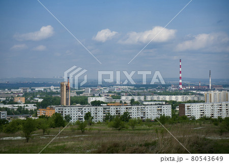 An industrial city on the horizon against the backdrop of a cloudy sky. 80543649