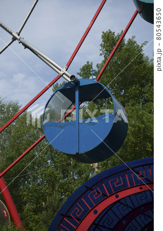Blue cabin of the round shaped Ferris wheel against the background of the blue sky. 80543650
