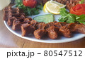 Cig kofte (raw meatball) with lettuce, tomato, pickle and lemon on the white plate. Turkish food Raw Meat ( Cig Kofte ) from traditional Turkish cuisine 80547512