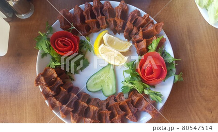 Cig kofte (raw meatball) with lettuce, tomato, pickle and lemon on the white plate. Turkish food Raw Meat ( Cig Kofte ) from traditional Turkish cuisine Cig kofte (raw meatball) with lettuce, tomato, pickle and lemon on the white plate. Turkish food Raw Meat ( Cig Kofte ) from traditional Turkish cuisine 80547514