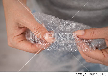 The faceless woman bursts the packaging bubbles. Antistress 80548516
