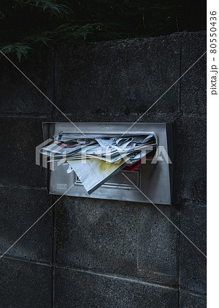 住人がいなくなり郵便物がいっぱいになった住居のポスト 住人がいなくなり郵便物がいっぱいになった住居のポスト 80550436