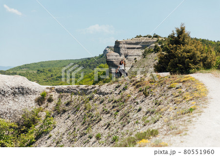 a beautiful woman walking along a mountain road on a hiking trip a beautiful woman walking along a mountain road on a hiking trip 80551960