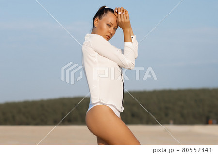 Sexy woman taking off top on beach - Stock Photo [79816064] - PIXTA