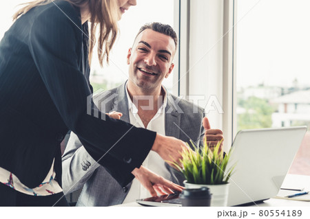 Businessman and businesswoman working in office. 80554189