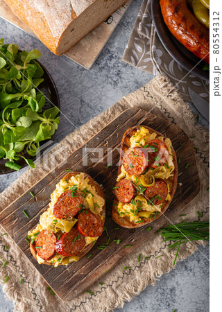 Scrambled eggs with sausage and herbs Scrambled eggs with sausage and herbs 80554312