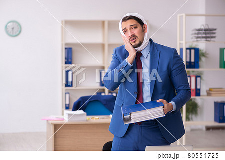 Young male employee suffering from toothache at workplace Young male employee suffering from toothache at workplace 80554725