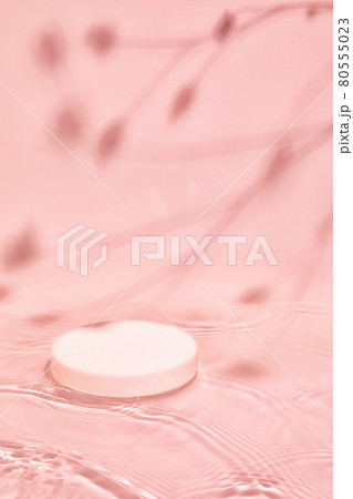 white cylinder podium on pink calm water with soft plants shadows 80555023