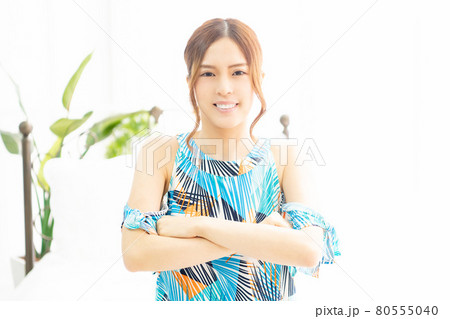 明るい部屋の窓際で、腕を組んで笑っている、ワンピースを着た若い女性 明るい部屋の窓際で、腕を組んで笑っている、ワンピースを着た若い女性 80555040
