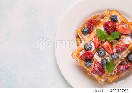 Belgian waffles with strawberries, blueberries and syrup, homemade healthy breakfast Belgian waffles with strawberries, blueberries and syrup, homemade healthy breakfast 80555766