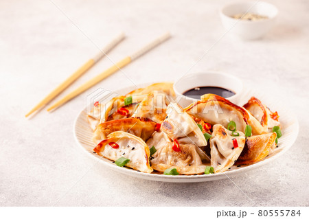 Fried dumplings served with green onions. 80555784