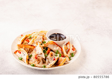 Fried dumplings served with green onions. 80555786