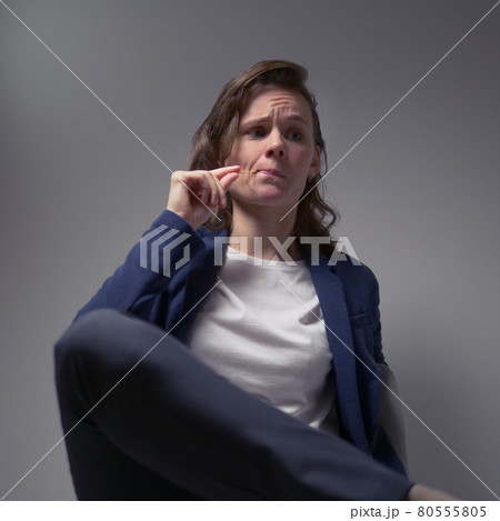 cool business woman in a jacket sitting in a chair on a dark background cool business woman in a jacket sitting in a chair on a dark background 80555805