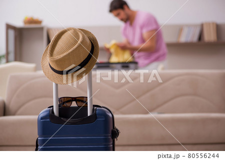Young man preparing for trip at home Young man preparing for trip at home 80556244