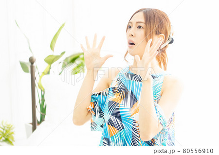 明るい部屋の窓際で、驚いたジェスチャーをする、ワンピースを着た若い女性 明るい部屋の窓際で、驚いたジェスチャーをする、ワンピースを着た若い女性 80556910