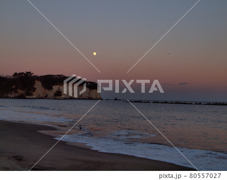 日立市川尻海岸の夕暮れ時、残照の赤味が残る空に月が昇る。白い波とのコラボレーションが印象的で綺麗だ。 80557027
