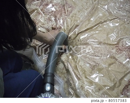 圧縮袋に布団をいれて掃除機で吸う　～Put the futon in the compression 80557383