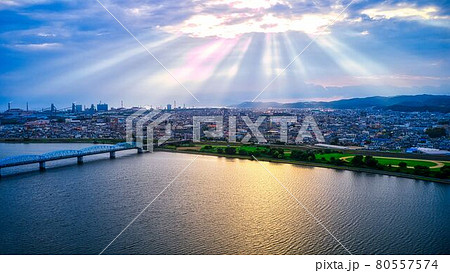 雲の隙間から幻想的な陽の光線が差した和歌山市の紀ノ川の河口の景色をドローンで空撮 80557574