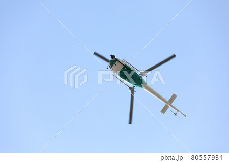 Helicopter with video surveillance system flying in blue sky 80557934