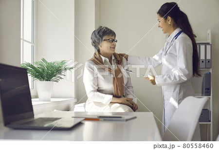 Female doctor has fun talking to an elderly woman who came to the clinic for a medical examination. 80558460