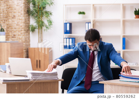 Young male employee in multitasking concept 80559262